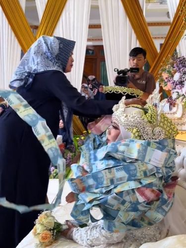 Pasangan pengantin ini dikalungi lembaran uang kertas di Bangkalan, Madura, viral di TikTok.
