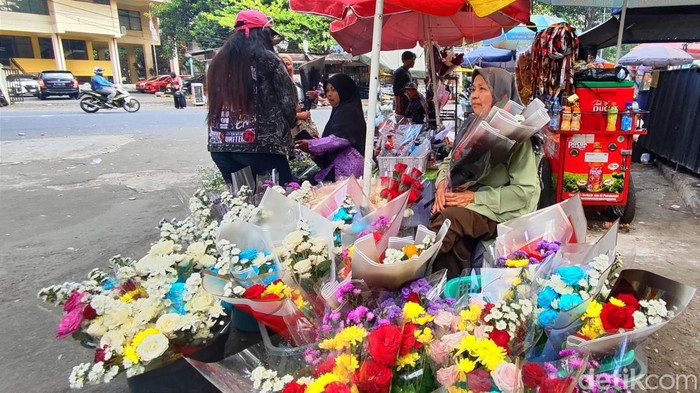 Sumiati yang sedang menjual buket bunga di gerbang samping Unpad DU pada hari wisuda
