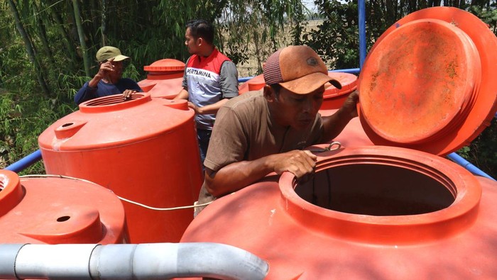 Perwira Pertamina Subholding Upstream (kanan) mengecek tandon air di Desa Rahayu, Soko, Tuban, Jawa Timur, Rabu (8/11/2023). Dibangunnya 4 sumur Hippam melalui program Banyu Asih oleh Pertamina EP Sukowati Field tersebut menjadi solusi bagi 980 kepala keluarga di daerah itu yang kesulitan air bersih pada saat musim kemarau. ANTARA FOTO/Budi Candra Setya/aww.