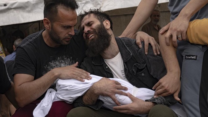 Palestinians mourn their relatives killed in the Israeli bombardment of the Gaza Strip in a morgue in Khan Younis, Sunday, Oct. 29, 2023. ( AP Photo/Fatima Shbair)