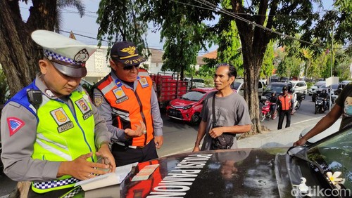 Petugas Dishub dan polisi menilang salah seorang pengguna jalan.