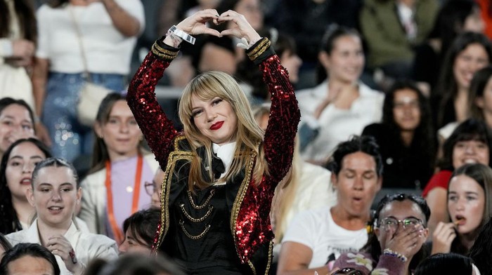 A fan flashes a hand-heart hand sign as she waits for the start of Taylor Swift: The Eras Tour concert, in Buenos Aires, Argentina, Thursday, Nov. 9, 2023. (AP Photo/Natacha Pisarenko)