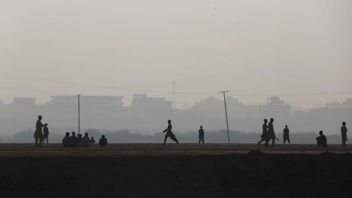 Bermain Kriket di Tengah Polusi Udara Karachi A man exercises amid smog, with buildings in the background, in Karachi, Pakistan, November 10, 2023. REUTERS/Akhtar Soomro
