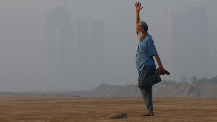 Bermain Kriket di Tengah Polusi Udara Karachi A man exercises amid smog, with buildings in the background, in Karachi, Pakistan, November 10, 2023. REUTERS/Akhtar Soomro