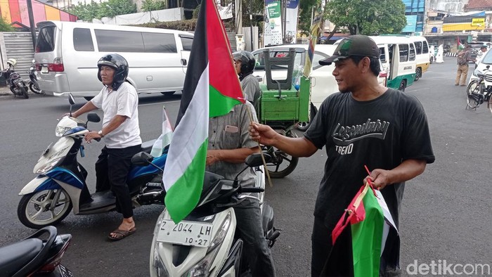 Pedagang bendera dan atribut Palestina menjajakan dagangannya.