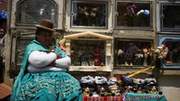 Seorang wanita adat beristirahat di samping tengkorak pada Hari Tengkorak atau natitas, di La Paz, Bolivia, 8 November 2023.