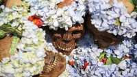Teman dan keluarga di Pemakaman Kota La Paz menghiasi tengkorak tersebut dengan beragam benda selama kunjungan mereka.  