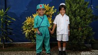 Zeko (6) dan Lala (6) berpose menggunakan pakaian perawat.