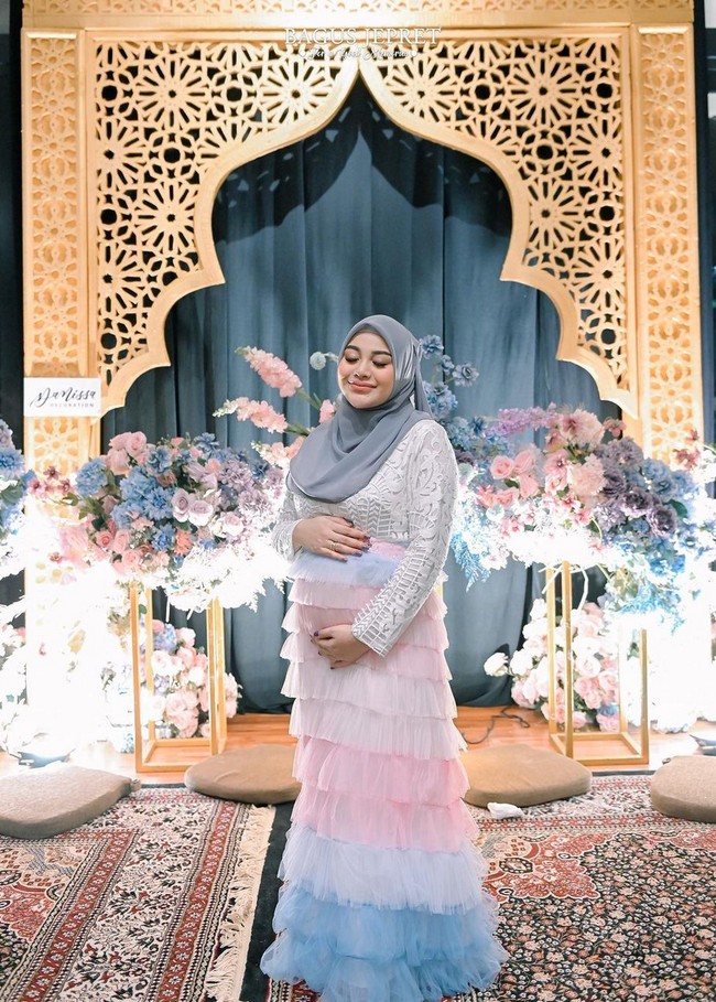 Saat menggelar pesta gender reveal, Aurel bergaya girlie dengan gaun ruffle warna pastel. Gaun merupakan gabungan dari atasan bordir serta rok tutu bergradasi warna pink ke biru. Foto: Instagram/@aurelie.hermansyah