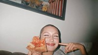 Senyuman manis juga ia tampilkan dalam sebuah foto ketika menikmati sepotong pizza. Pizza ternyata benar-benar menjadi makanan favorit Bella ya! Foto: Instagram @bellahadid