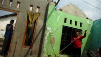 Personel PMI menata barang-barang milik warga yang atap rumahnya rusak akibat angin puting beliung. 