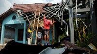 Sejumlah warga memperbaiki atap rumah yang rusak usai diterjang puting beliung di Desa Kedungsukun, Kabupaten Tegal, Jawa Tengah, Jumat (10/11/2023). 