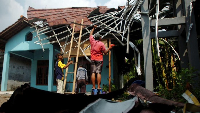 Sejumlah warga memperbaiki atap rumah yang rusak akibat angin puting beliung di Desa Kedungsukun, Kabupaten Tegal, Jawa Tengah, Jumat (10/11/2023). Menurut data pemerintah desa setempat sebanyak 10 rumah, dua tiang listrik dan satu masjid rusak akibat diterjang angin puting beliung.