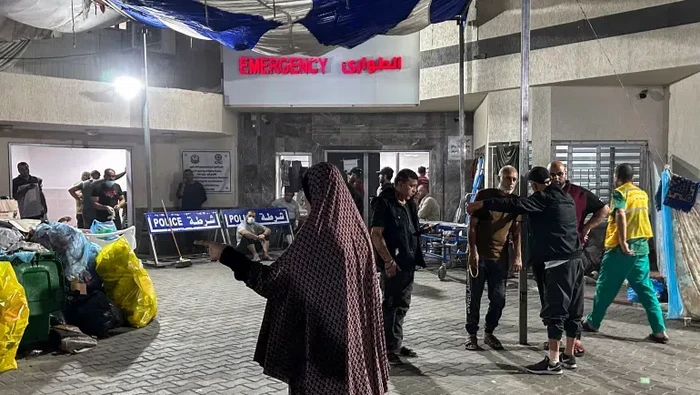 Orang-orang berdiri di luar bangsal darurat Rumah Sakit Al-Shifa di Kota Gaza pada Jumat (10/11/2023)