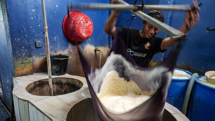 Pekerja menuang biji kedelai ke dalam mesin di lokasi produsen tahu di Palu, Sulawesi Tengah, Jumat (10/11/2023). Selain melakukan penyesuaian harga, sejumlah produsen tahu di wilayah itu juga terpaksa mengurangi produksi 10 hingga 15 persen dari biasanya sebagai akibat dari kenaikan harga bahan baku kedelai sejak dua pekan terakhir.