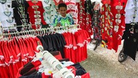 Pedagang menjual atribut timnas sepakbola Indonesia di kawasan Stadion Gelora Bung Tomo, Surabaya, Jawa Timur. 