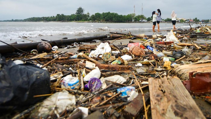 Pengunjung berjalan di antara sampah yang berserakan di Pantai Ulak Karang, Padang, Sumatera Barat, Jumat (10/11/2023). Pantai yang berada di kawasan kampus dan menjadi wisata alternatif bagi mahasiswa dan masyarakat umum tersebut dipenuhi sampah kayu dan plastik yang dibawa dari hulu Sungai Batang Kuranji. ANTARA FOTO/Iggoy el Fitra/rwa.