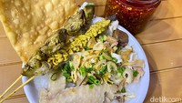 Aneka pelengkap bubur di sini termasuk sate ati, sate usus, kulit ayam basah, dan pangsit goreng. Semakin enak ketika bubur ditambahkan chili oil.