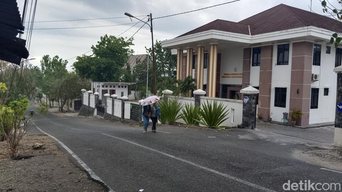 Warga mengenakan payung saat Kota Kupang, NTT diguyur hujan perdana, Sabtu (11/11/2023). (Yufengki Bria/detikBali)