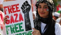 Warga membentangkan poster saat aksi bela Palestina di Jalan Gubernur Suryo, Surabaya, Jawa Timur, Minggu (12/11/2023). Aksi tersebut sebagai bentuk pembelaan dan kepedulian terhadap Palestina yang mengalami penderitaan akibat serangan militer Israel. ANTARA FOTO/Didik Suhartono.