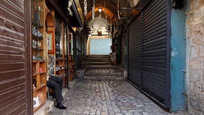 Shopkeepers wait for tourists as other souvenir shops are closed, amid the ongoing conflict between Israel and the Palestinian Islamist group Hamas, in the old city of Jerusalem, November 10, 2023. REUTERS/Reinhard Krause