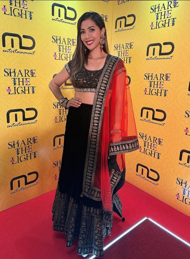 Presenter dan penulis buku Nadia Mulya tampil simple dengan crop dan rok H-line berwarna hitam yang dihias bordiran silver. Dia melengkapi penampilannya dengan selendang merah transparan yang disampirkan di bahu. Foto: Instagram/@manojpunjabimd