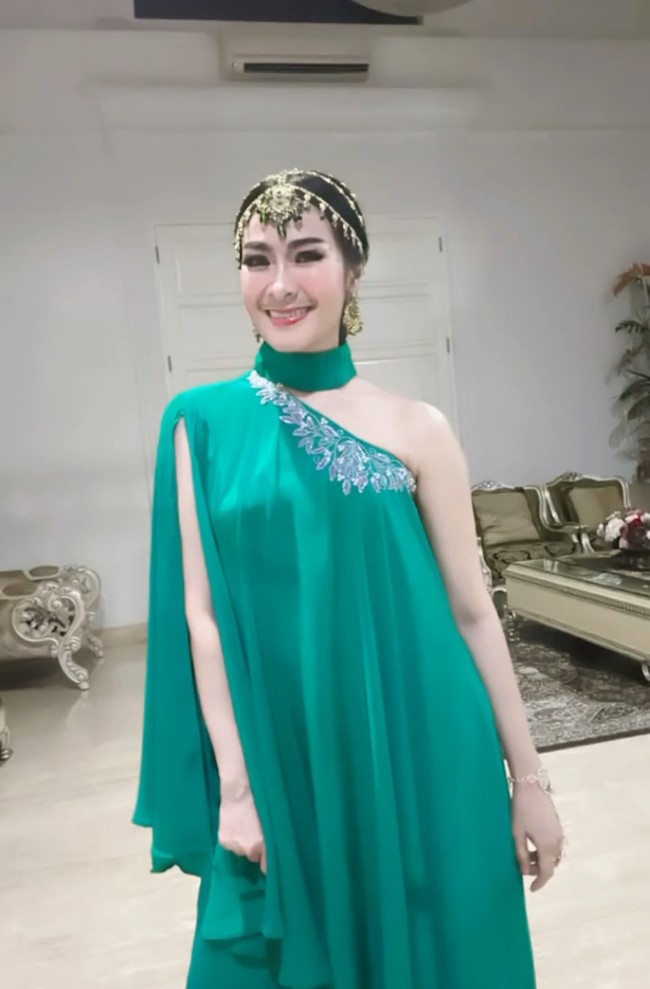 Iis Dahlia memilih busana asimetris bernuansa cerah untuk memeriahkan suasana. Penyanyi dangdut ini memasukkan unsur India di kepala dengan hiasan matha patti. Foto: Instagram/@manojpunjabimd