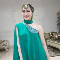 Iis Dahlia memilih busana asimetris bernuansa cerah untuk memeriahkan suasana. Penyanyi dangdut ini memasukkan unsur India di kepala dengan hiasan matha patti. Foto: Instagram/@manojpunjabimd