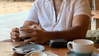Seperti pada momen ini, saat liburan ke pantai, Ario Bayu tak lupa untuk menikmati secangkir kopi dan berbagai camilan. Foto: Instagram @bayu_ario