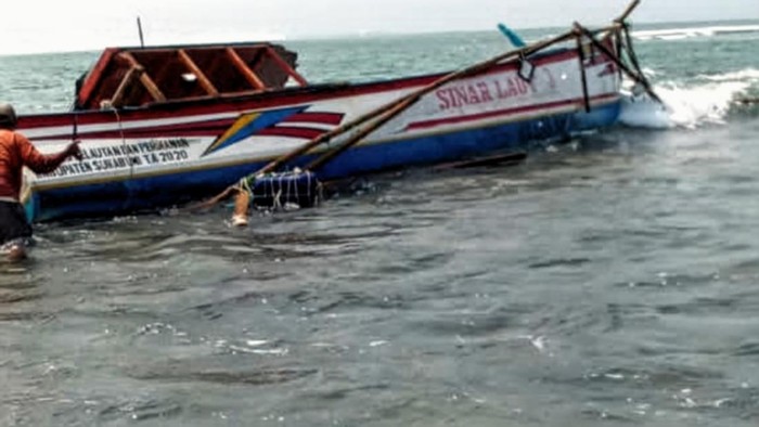 Nelayan saat mengevakuasi perahu yang bocor di perairan Ujunggenteng, Sukabumi