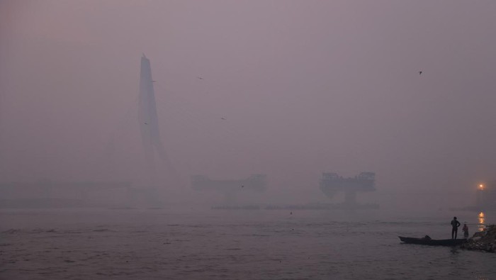 Men talk to each other on the banks of the rive Yamuna on a smoggy morning in New Delhi, India, November 13, 2023. REUTERS/Anushree Fadnavis