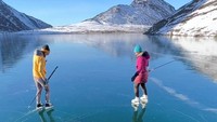 Danau yang membeku itu tampak dilapisi es yang bening sehingga bagian dasar danau bisa terlihat.  