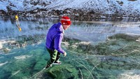 Warga setempat memanfaatkan danau yang membeku untuk bermain seluncur.  