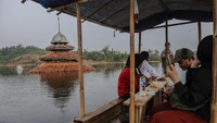 Pengunjung menaiki perahu getek menuju kampung yang tenggelam di Kampung Sinday, Lebak, Banten, Minggu (12/11/2023).