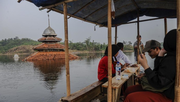 Pengunjung menaiki perahu getek menuju kampung yang tenggelam di Kampung Sinday, Lebak, Banten, Minggu (12/11/2023). Wisatawan bisa mengunjungi kampung tenggelam yang dijadikan Bendungan Karian tersebut menggunakan perahu dengan ongkos Rp20 ribu per orang. ANTARA FOTO/Muhammad Bagus Khoirunas/aww.