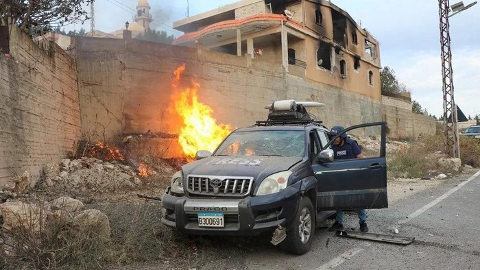 Flames erupt next to a press car following reported Israeli shelling in Lebanons southern border village of Yaroun on November 13, 2023. (AFP)