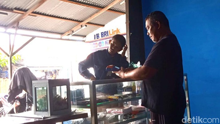 Ilham Ridwan saat melayani nasabah yang ingin bertransaksi. (Andika Syahputra/detikSumut)