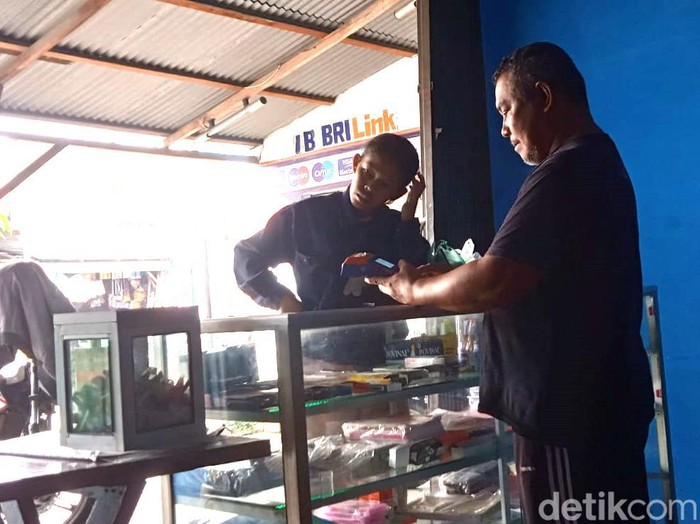 Ilham Ridwan saat melayani nasabah yang ingin bertransaksi. (Andika Syahputra/detikSumut)