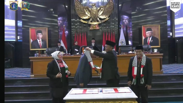 Ketua DPRD DKI Prasetio Edi Marsudi mengalungkan syal bendera Palestina-Indonesia ke Pj Gubernur DKI Jakarta Heru Budi Hartono.