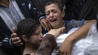 Dua orang anak tak kuasa menahan tangis saat kerabatnya menjadi korban tewas akibat serangan Israel di Jalur Gaza, Selasa (14/11/2023).  
