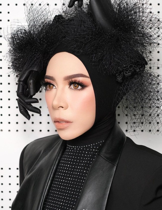 Syuting video klip, Melly Goeslaw berbusana serba hitam tapi tetap edgy. Kali ini ibu dua anak tersebut memakai headpiece bentuk tangan di atas hijabnya. Foto: Instagram/@melly_goeslaw