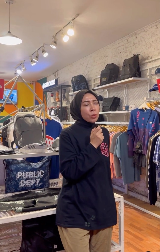 Berbusana simple minimalis, pelantun lagu Bagaikan Langit itu tampak berada di toko pakaian mengenakan kemeja hitam dan celana chino warna camel. Foto: Instagram/@melly_goeslaw