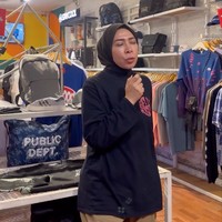 Berbusana simple minimalis, pelantun lagu Bagaikan Langit itu tampak berada di toko pakaian mengenakan kemeja hitam dan celana chino warna camel. Foto: Instagram/@melly_goeslaw