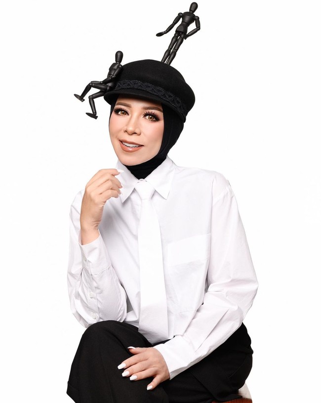 Bergaya androgini, caleg dari Partai Gerindra ini tampil monokrom mengenakan kemeja putih dan celana hitam. Statement gaya datang dari headpiece berhias patung manusia karya desainer aksesori Rinaldy A Yunardi. Foto: Instagram/@melly_goeslaw