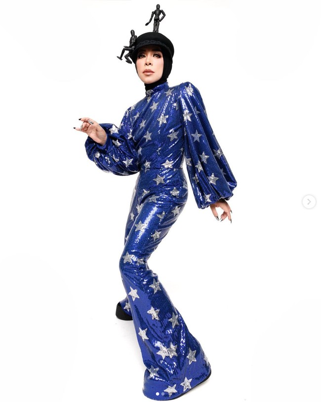 Musisi 49 tahun ini kerap bergaya nyentrik. Termasuk penampilannya ini, dia memakai jumpsuit biru dengan motif bintang warna silver. Dalam unggahan terbaru, dia menyempatkan mempromosikan dirinya sebagai caleg. Bismillaah #baladmelly doain ya 🙏🏻, inget lagu ini, nanti kita nyanyi bareng ya, tulisnya. Foto: Instagram/@melly_goeslaw