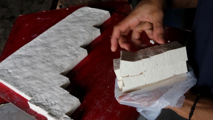 Sejumlah pekerja menyelesaikan proses pembuatan tahu di tempat produksi tahu Desa Lapang, Johan Pahlawan, Aceh Barat, Aceh, Selasa (14/11/2023). Kenaikan harga kacang kedelai impor dari Rp11.600 per kilogram menjadi Rp13.400 per kilogram sejak sebulan terakhir menyebabkan produsen tahu di wilayah tersebut terpaksa menaikkan harga tahu menjadi Rp60.000 per papan dan mengurangi takaran produksi sekitar 15 persen dari biasanya agar terhindar dari kerugian. ANTARA FOTO/Syifa Yulinnas/rwa.