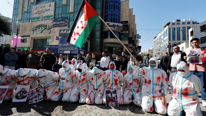 Protesters wear shrouds during a protest in solidarity with Gaza and Palestinian prisoners in the Israeli jails as the conflict between Israel and Palestinian Islamist group Hamas continues, in Hebron, in the Israeli-occupied West Bank November 14, 2023. REUTERS/Mussa Qawasma