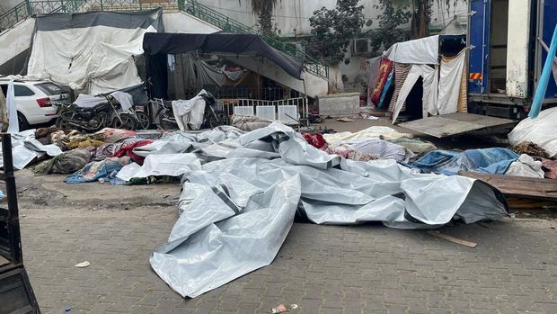 Jenazah warga Palestina yang tewas dalam serangan Israel tergeletak di halaman rumah sakit Al Shifa. (Ahmed El Mokhallalati/via REUTERS)