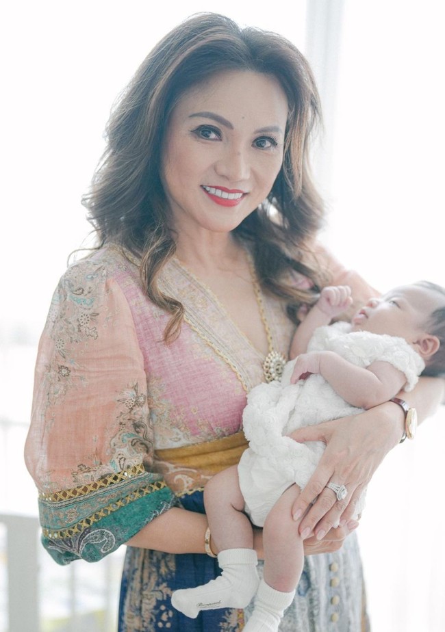 Ikut hadir di acara satu bulanan cucu tercinta, Susy Sariaatmadja tampil menawan mengenakan baju bermotif. Tersenyum ke arah kamera, Susy tampak menggendong baby Julia. Foto: Instagram/@jessicatanoe