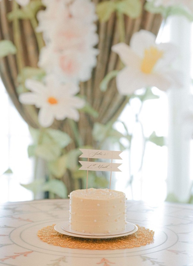 Dekorasi di acara 1 bulanan anak Jessica pun tampak amat simpel, hanya dihiasi bunga-bunga berwarna putih untuk menjadi latar belakangnya. Demikian pula dengan kue 1 bulanan sang putri yang berwarna putih, simpel namun tetap elegan dengan dihiasi taburan seperti mutiara dan tulisan ‘Julia’s 1st Month’. Foto: Instagram/@jessicatanoe